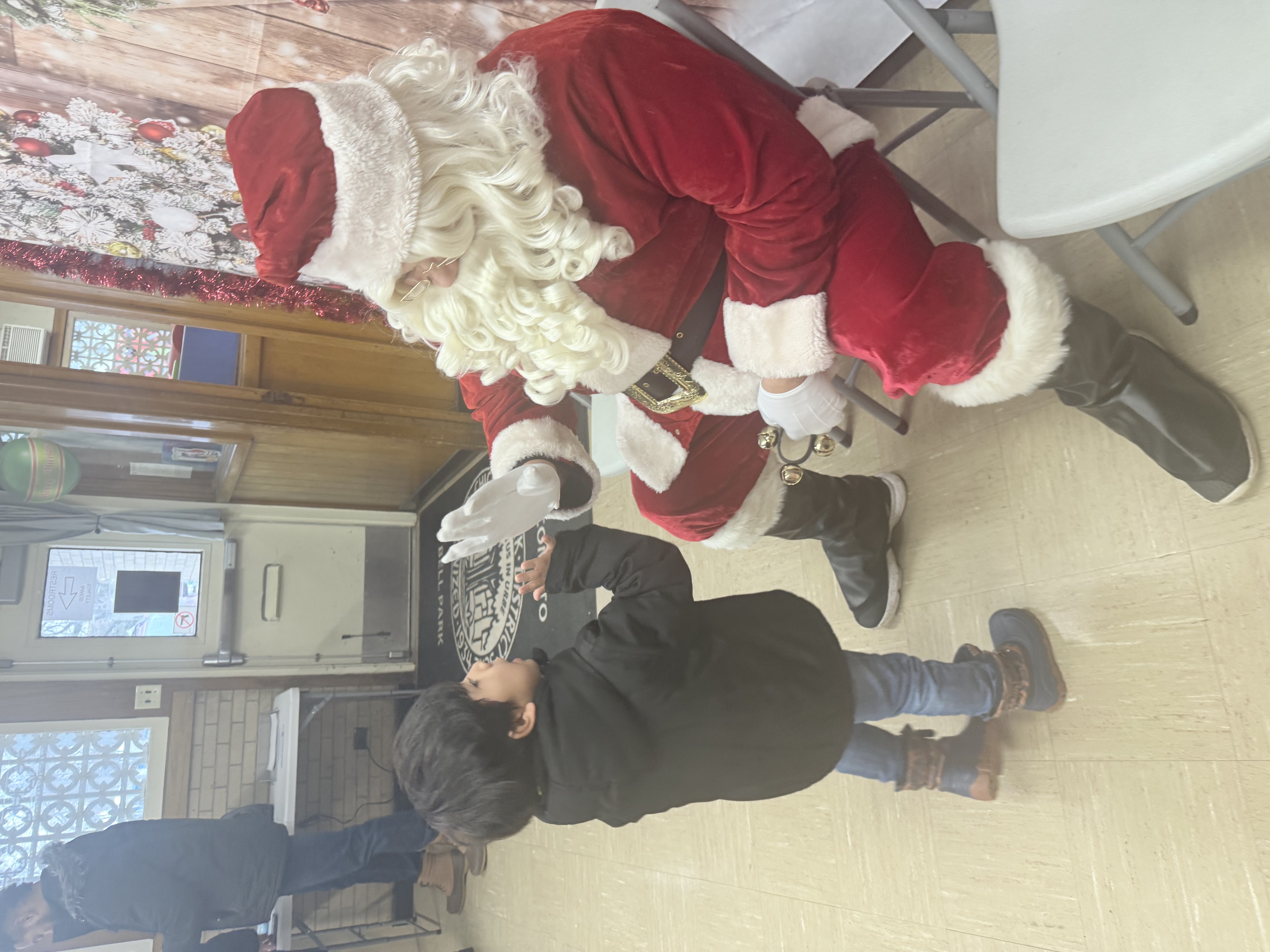 Santa Claus meets a young child.